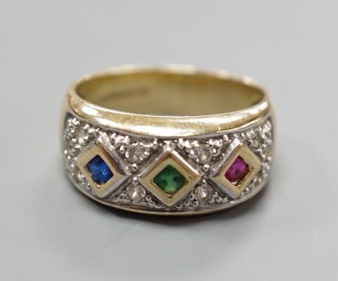 A modern 375 yellow metal and four colour cubic zirconia set dress ring, size O, gross weight 4.6 grams.